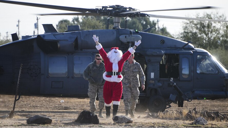 Santa Claus, Col. Scott Campbell, 355th Fighter Wing commander, and Chief Master Sgt. Jeremy Ravlin, 355th FW command chief,  exit from an HH-60G Pave Hawk during the Santa’s in Blue event at San Xavier Mission School in Tucson, Ariz., Dec. 13, 2016. This year, Santa delivered gifts donated by D-M Airmen to more than 1,000 students at four different schools in the Tucson area. (U.S. Air Force photo by Airman Nathan H. Barbour)