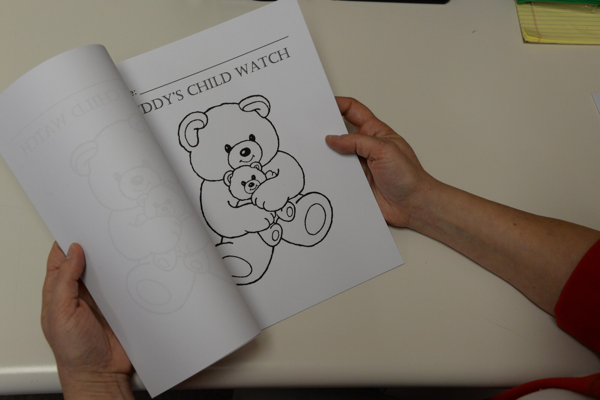 Roberta Textor, Teddy’s Child Watch Program director, flips through several teddy bear coloring pages inside the Teddy’s Child Watch facility at Travis Air Force Base, Calif., Dec. 12, 2016. The facility offers military families attending medical appointments at USAF David Grant Medical Center with childcare free of charge. The Teddy’s Child Watch Program offers children many activities including movies, learning games and themed play areas. (U.S. Air Force photo/Tech. Sgt. James Hodgman)