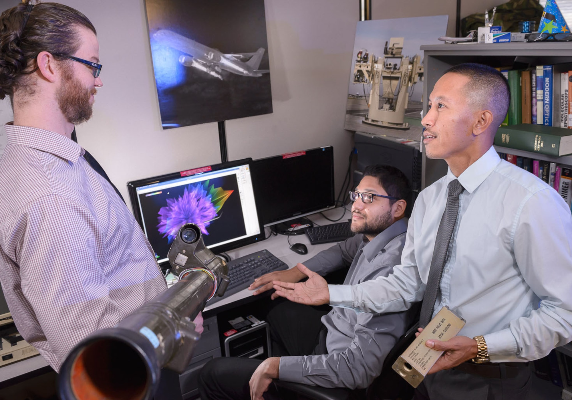 Using modeling and simulation tools, Seth Kubli, electronic warfare analyst, Ismael Zapata, electronic warfare engineer, and Ronald Magharing, chief, Signature Element, 57th IS, work to determine what U.S. military planes look like to enemy weapons and what countermeasures might be effective against those weapons.