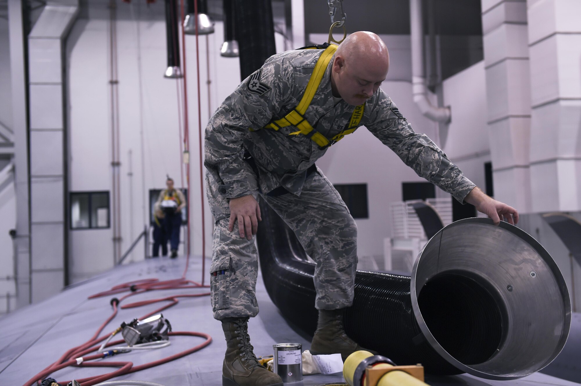 U.S. Air Force Staff Sgt. Jacobb Nordstrom, 19th Maintenance Squadron fuel systems repair craftsman, moves an air duct to assist an Airman performing repairs inside a C-130J fuel cell Dec. 5, 2016, in Hangar 232 on Little Rock Air Force Base, Ark. U.S. Air Force Airmen are required to wear specially made coveralls and respirators whenever they enter a fuel tank. (U.S. Air Force photo/Senior Airman Harry Brexel)