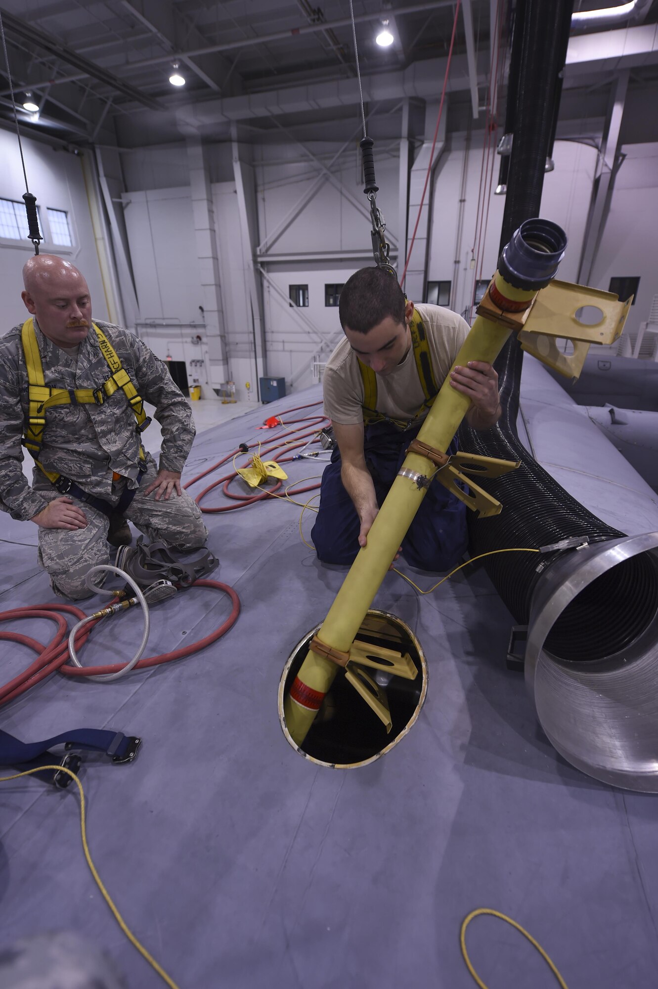 U.S. Air Force Staff Sgt. Jacobb Nordstrom, left, 19th Maintenance Squadron fuel systems repair craftsman, assists Senior Airman Craig Martin, 19th MXS fuel systems repair journeyman, install a refuel pipeline manifold on a C-130J fuel tank Dec. 5, 2016, in Hangar 232 on Little Rock Air Force Base, Ark. The 19th MXS fuel systems repair flight works on various fuel and water cell tanks. (U.S. Air Force photo/Senior Airman Harry Brexel)
