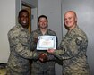 Tech. Sgt. Jordan Boothe, BLAZE 5/6 member, right, hands Airman Ryan Heman-Ackah, 14th Operations Support Squadron Aviation Resource Management Apprentice, left, the BLAZE 5/6 Leadership Highlight award Dec. 5, 2016, at Columbus Air Force Base, Mississippi. Heman-Ackah was nominated by his supervisor Staff Sgt. Jimmy Phillips, center. The Blaze 5/6 Leadership Highlight award is presented to members in the ranks of Senior Airman and below who have stepped up and demonstrated leadership skills nominated by noncommissioned officers in their respective work centers. (U.S. Air Force photo by Melissa Doublin)