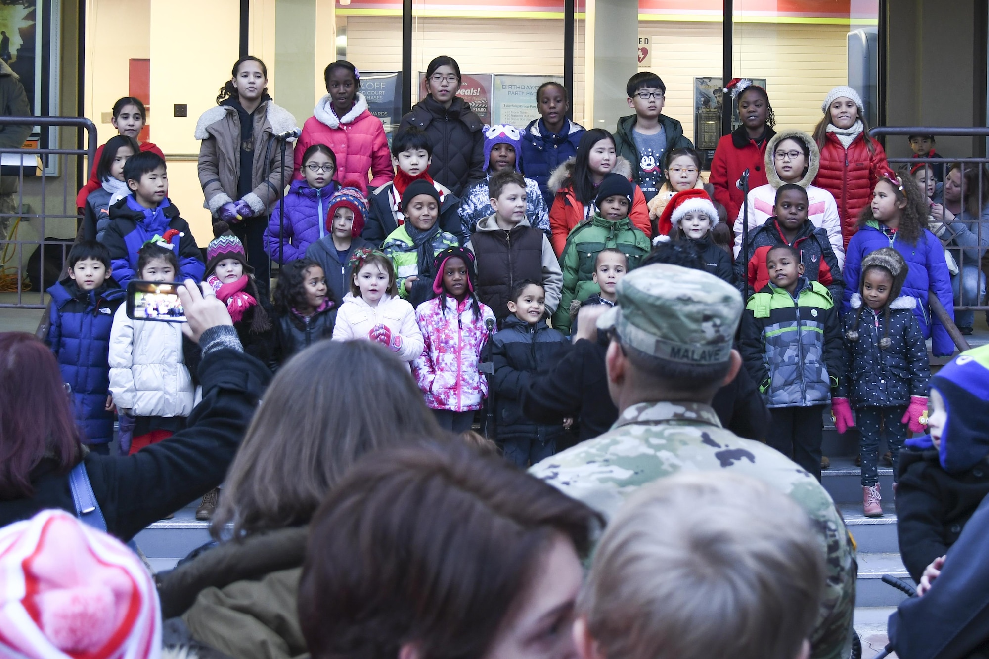 Children from the Osan Chapel Children’s Choir perform Christmas carols for the Christmas tree lighting ceremony at Osan Air Base, Republic of Korea, Dec. 8, 2016. Hundreds of service members and their families gathered in the “Main Square” in front of the base theater to witness the lighting of the tree. (U.S. Air Force photo by Tech. Sgt. Rasheen Douglas)
