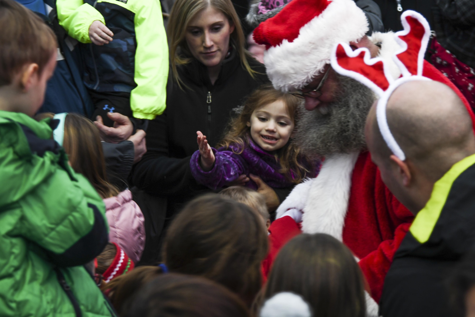 Santa Claus passes out candy to children during the Christmas tree lighting ceremony at Osan Air Base, Republic of Korea, Dec. 8, 2016. Osan children sang Christmas carols before Santa appeared, riding on a fire engine. (U.S. Air Force by Tech. Sgt. Rasheen Douglas)