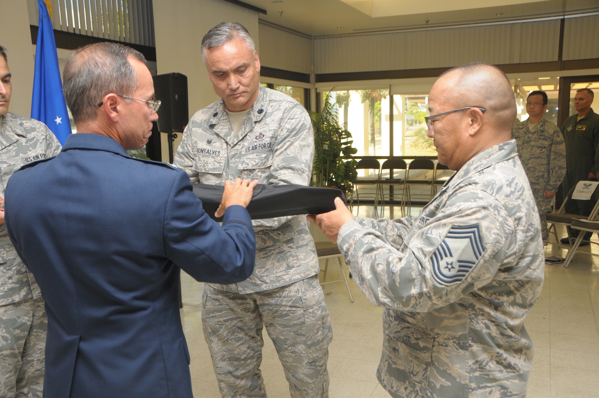 U.S. Air Force Col. Duke Ota, commander, 154th Mission Support group, and Lt. Col. Marc Gonsalves commander, 293rd Combat Communications Squadron case the unit flag together during the 293rd CBCS deactivation ceremony held at Joint Base Pearl Harbor-Hickam, Hawaii, Nov. 05, 2016. The deactivation ceremony is a time honored military tradition in which a unit is deactivated and cases the colors to signify the returning of the unit designation. (U.S. Air National Guard photo by Airman 1st Class Stan Pak/released) 