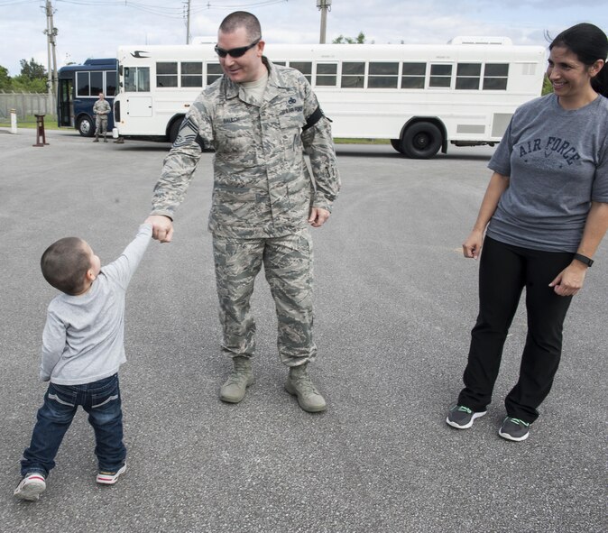 U.S. Air Force Senior Master Sgt. Collin Baulch, 18th Munitions Squadron production flight chief, is congratulated by his son for his selection to chief master sergeant as his wife observes Dec. 8, 2016, at Kadena Air Base, Japan. Many senior NCOs credit their families for helping them progress throughout their Air Force careers. (U.S. Air Force photo by Senior Airman Lynette M. Rolen/Released)