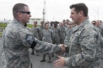 U.S. Air Force Col. Christopher Amrhein, 18th Wing vice commander, congratulates Senior Master Sgt. Collin Baulch, 18th Munitions Squadron production flight chief, for his selection to chief master sergeant Dec. 8, 2016, at Kadena Air Base, Japan. Through exemplary leadership, the best senior noncommissioned officers progress to the rank of chief master sergeant. (U.S. Air Force photo by Senior Airman Lynette M. Rolen/Released)