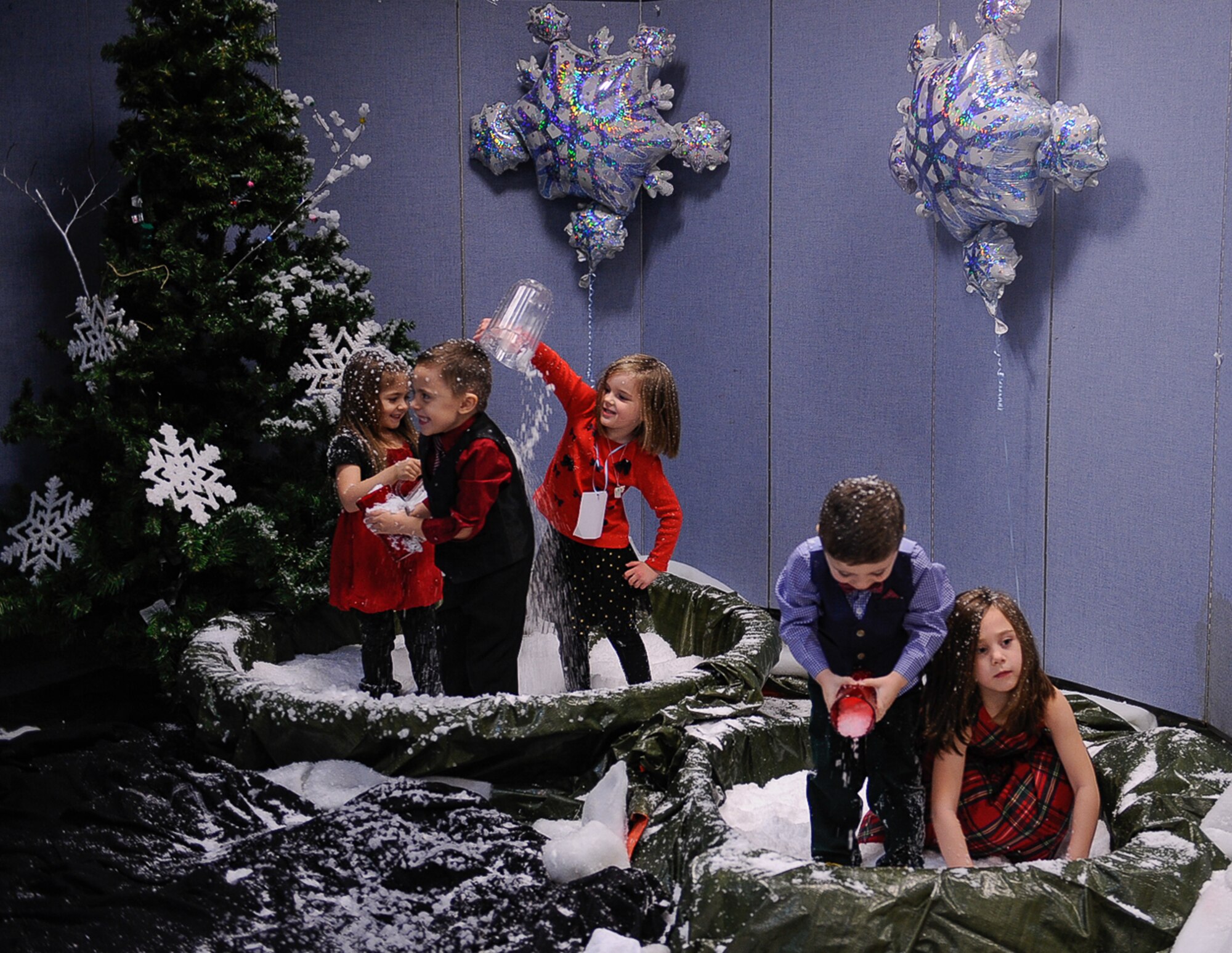 Children play in snow made from a snow machine during Elf Bootcamp at Ramstein Air Base, Germany, Dec. 12, 2016. Children came to the Ramstein Community Center to participate in Christmas arts and crafts, karaoke, and other games during the second annual Elf Bootcamp. (U.S. Air Force photo by Airman 1st Class Savannah L. Waters)