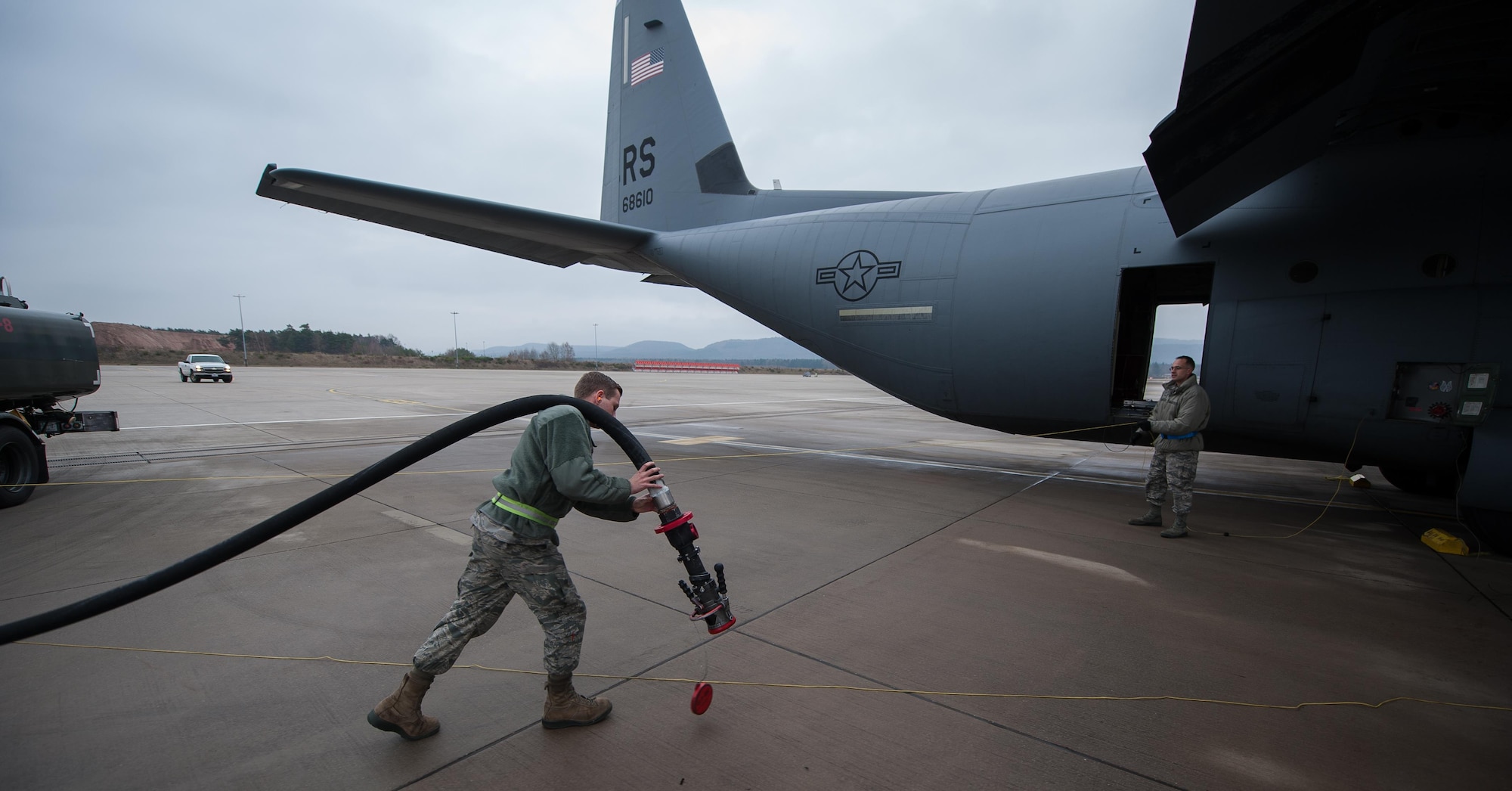 Airman 1st Class Austin Bashaw, 86th Logistics Readiness Squadron fuels specialist, carries a hose from the fuel truck to a parked C-130J Super Hercules at Ramstein Air Base, Germany, Dec. 12, 2016. Fuels specialists are also responsible for operating the vehicles, equipment and storage facilities that are essential to the refueling operation, while also ensuring the compliance of all safety regulations involved with handling these volatile liquids. (U.S. Air Force photo by Airman 1st Class Lane T. Plummer)