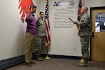 Lt. Col. Philip M. Brown, the 179th Force Support Squadron commander, administers the oath of enlistment Dec. 2, 2016, at the 179th Airlift Wing, Mansfield, Ohio. Cooper Burton is enlisting as his father, Senior Master Sgt. Roger Burton, the fire chief at the 179th AW, is reenlisting. 