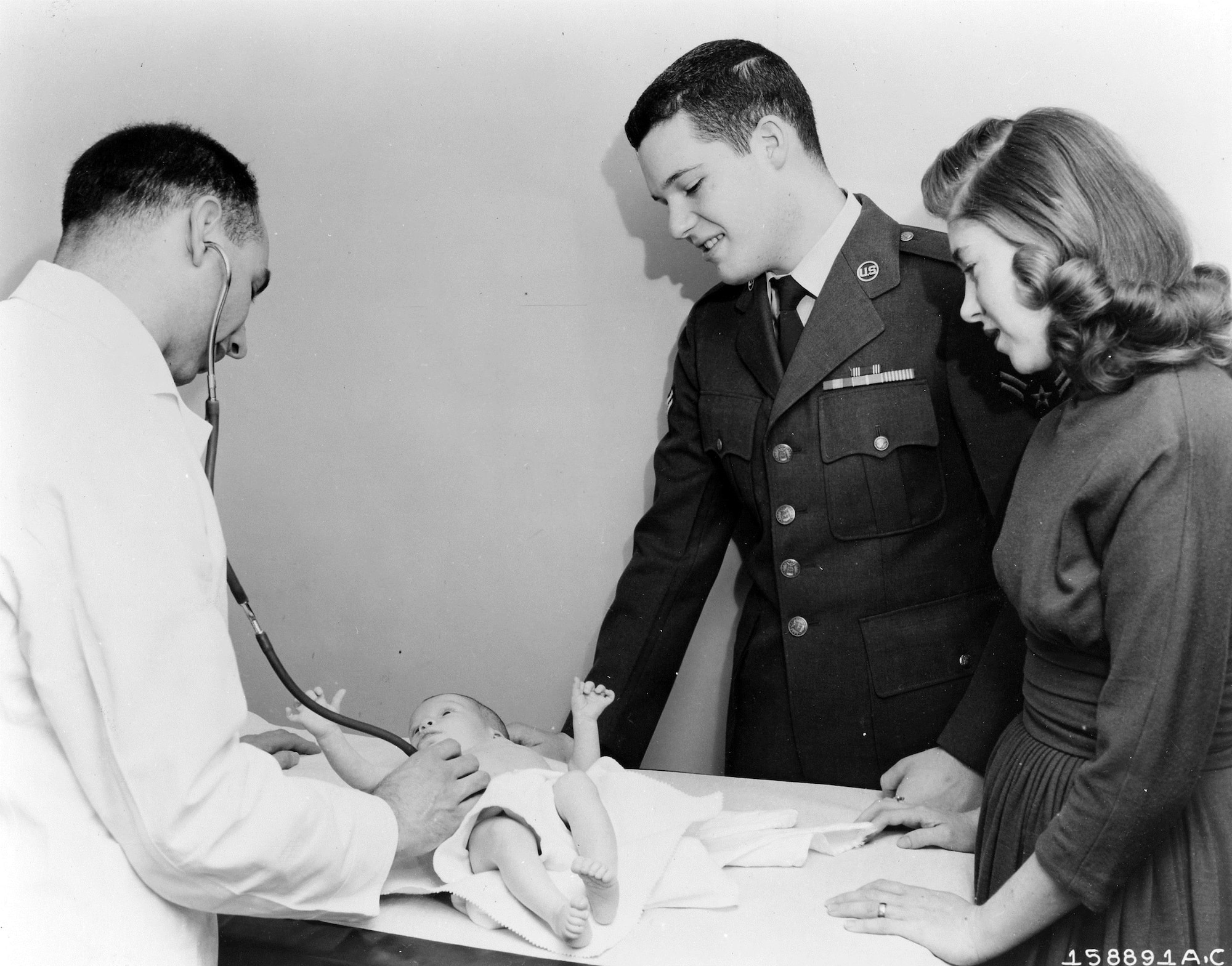 The Dependents’ Medical Care Act, effective since Dec. 7, 1956, enabled dependents of military personnel to be treated by civilian doctors in cases of pregnancy, serious injuries, or illnesses requiring hospitalization.  The law also opened up medical facilities of all services and the U.S. Public Health Service to Air Force dependents.  The Dependents’ Medical Care Act outlined operations of the program, specific exceptions, and eligibility requirements.  Here, an Airman and his wife get the final okay from the family doctor on the second visit.