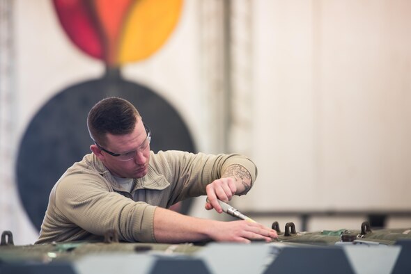(Vermont Air National Guard Staff Sgt. Joshua Thomas, 134th Expeditionary Fighter Squadron weapons maintenance technician, ensures the forward laser strap of a of a 500-pound joint direct attack munition is straight during the assembly process at the 407th Air Expeditionary Group, Southwest Asia, Dec. 2, 2016. The bombs will be used to fight ISIL in Iraq, which is a threat to the international community. (U.S. Air Force photo/Master Sgt. Benjamin Wilson)(Released)