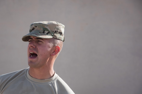 Senior Airman Mark Dunton, Engineering and Installation airfield systems technician, shouts instructions to his coworkers while installing communications systems at the 407th Air Expeditionary Group, Dec. 6, 2016. The engineering and installation team, forward deployed from Headquarters U.S. Air Force Central Command A6, invested more than 550 man-hours to connect the 407th Expeditionary Logistics Readiness Squadron compound with the main base. (U.S. Air Force photo/Master Sgt. Benjamin Wilson)(Released)