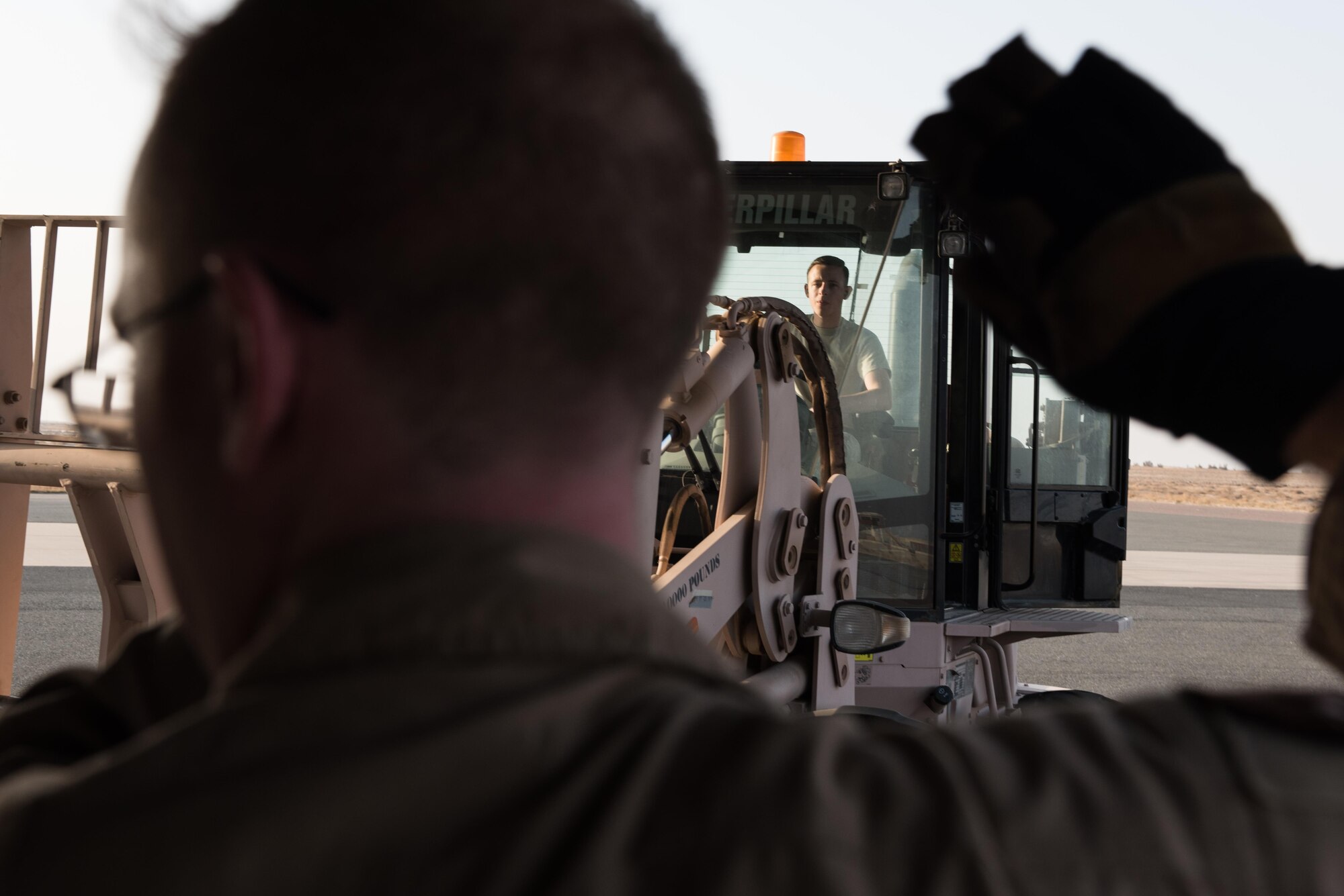 Senior Airman Corey Barnes, 8th Airlift Squadron loadmaster, guides Airman 1st Class Jay Rhodes, 407th Expeditionary Logistics Readiness Squadron, air terminal operations specialist, as he uses a forklift to unload cargo from a C-17 Globemaster III from Joint Base Lewis-McChord, Wash., delivering supplies to the 407th Air Expeditionary Group Dec. 6, 2016, in preparation for the arrival of an F-16 squadron. An advanced team prepared the installation for the arrival of the fighter jets, enabling the squadron to begin combat missions within 24 hours of arrival. (U.S. Air Force photo/Master Sgt. Benjamin Wilson)(Released)