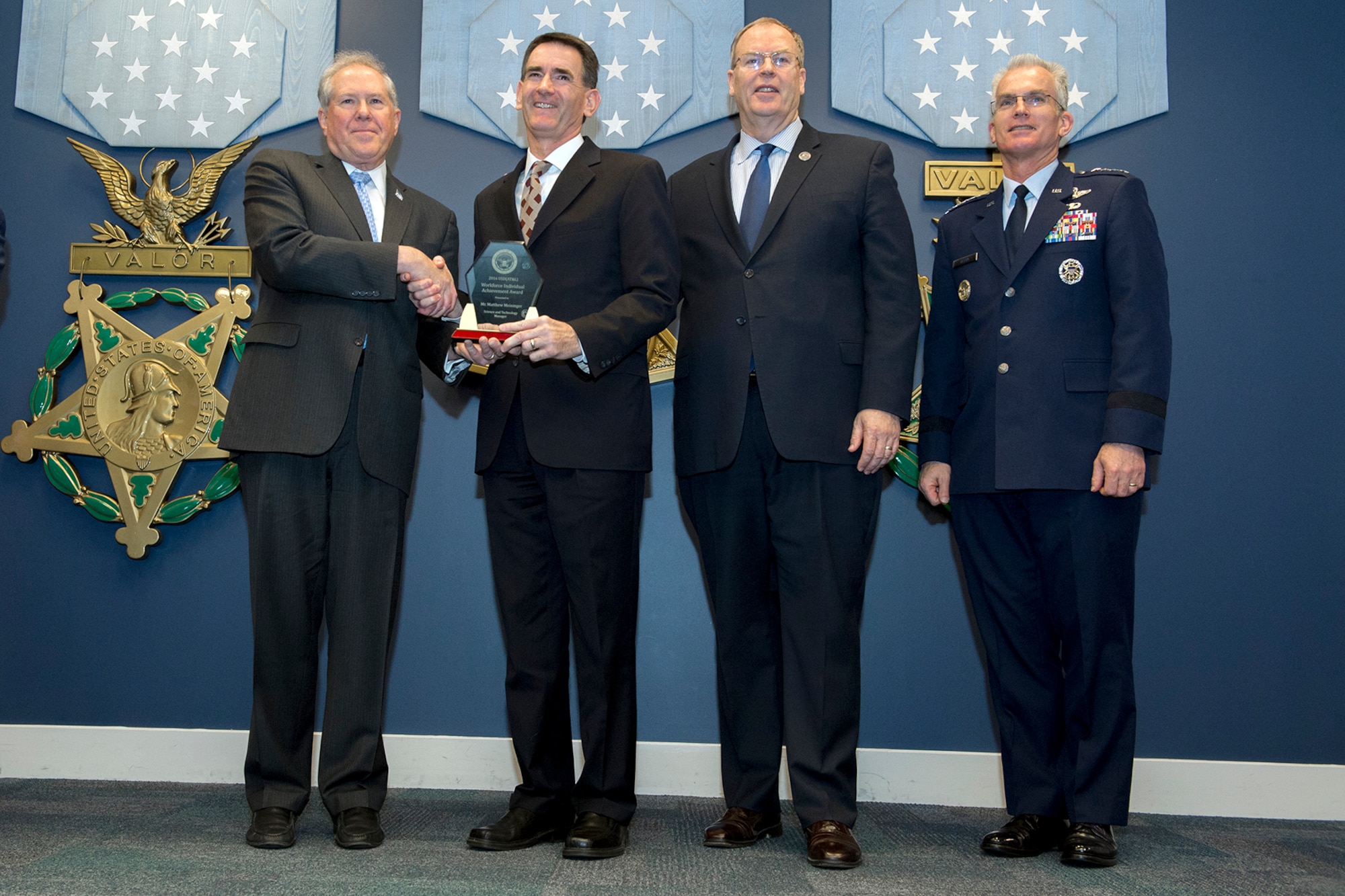 Frank Kendall, Under Secretary of Defense for Acquisition, left, presents Matthew Meininger with A Defense Acquisition Workforce Individual Award for science and technology management during a ceremony at the Pentagon on Dec. 8, 2016. Standing with them are Vice Chairman of the Joint Chiefs of Staff Gen. Paul J. Selva right, and Deputy Secretary of Defense Bob Work. (DoD photo) 