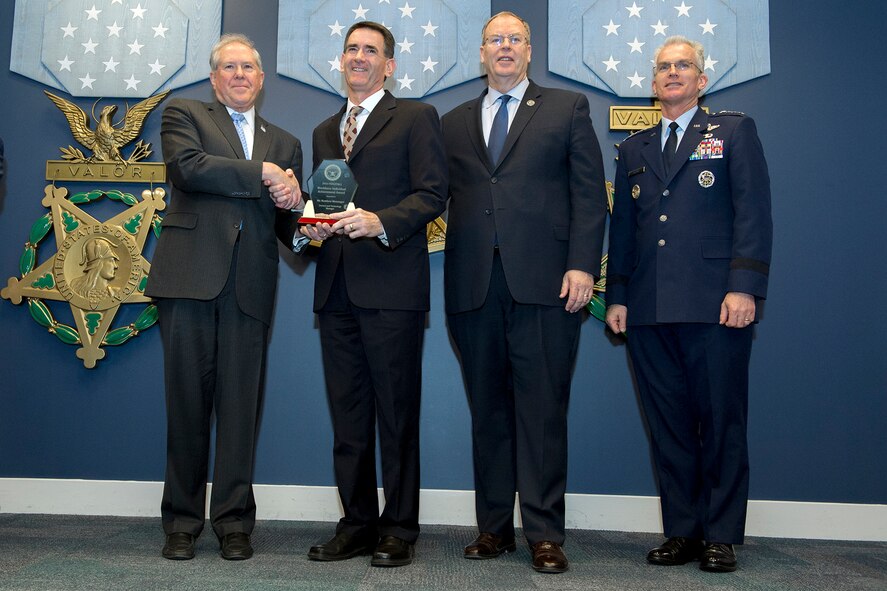 Frank Kendall, Under Secretary of Defense for Acquisition, left, presents Matthew Meininger with A Defense Acquisition Workforce Individual Award for science and technology management during a ceremony at the Pentagon on Dec. 8, 2016. Standing with them are Vice Chairman of the Joint Chiefs of Staff Gen. Paul J. Selva right, and Deputy Secretary of Defense Bob Work. (DoD photo) 