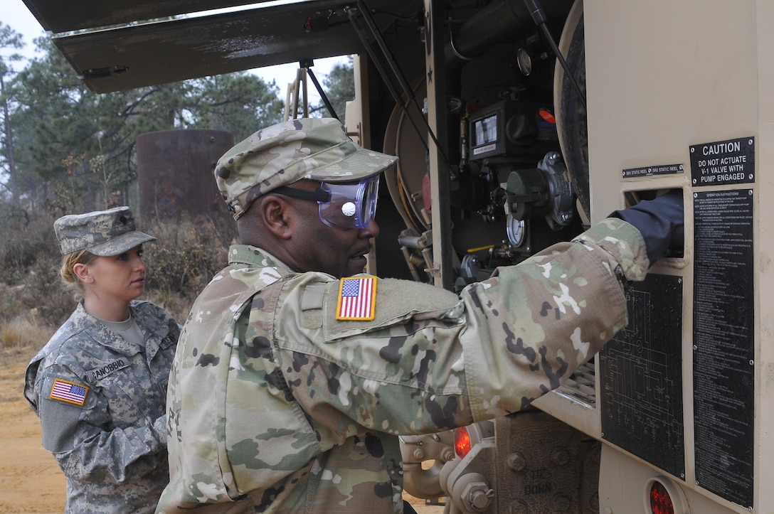 Spc. Caitlyn Canobbio with the 915th Transportation Company and Sgt. Curtis Chambers with the 459th Transportation Company prepare the fueling truck to distribute fuel to the generators during Operation Toy Drop XIX.  (U.S. Army photo by Sgt. 1st Class Stephen Crofoot, United States Army Civil Affairs and Psychological Operations Command [Airborne])