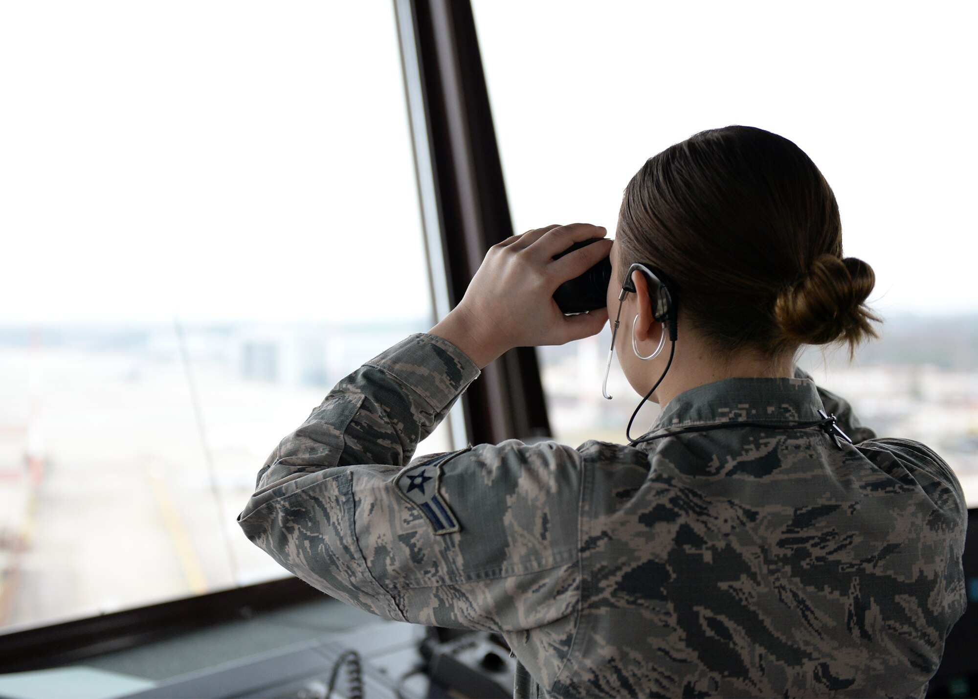 Airman 1st Class Paige Goulette, 86th Operations Support Squadron air traffic controller apprentice, looks out at aircraft at Ramstein Air Base, Germany, Dec. 12, 2016. Air traffic controllers must direct air traffic by providing instructions from radios to aircraft pilots. (U.S. Air Force photo by Senior Airman Jimmie D. Pike)