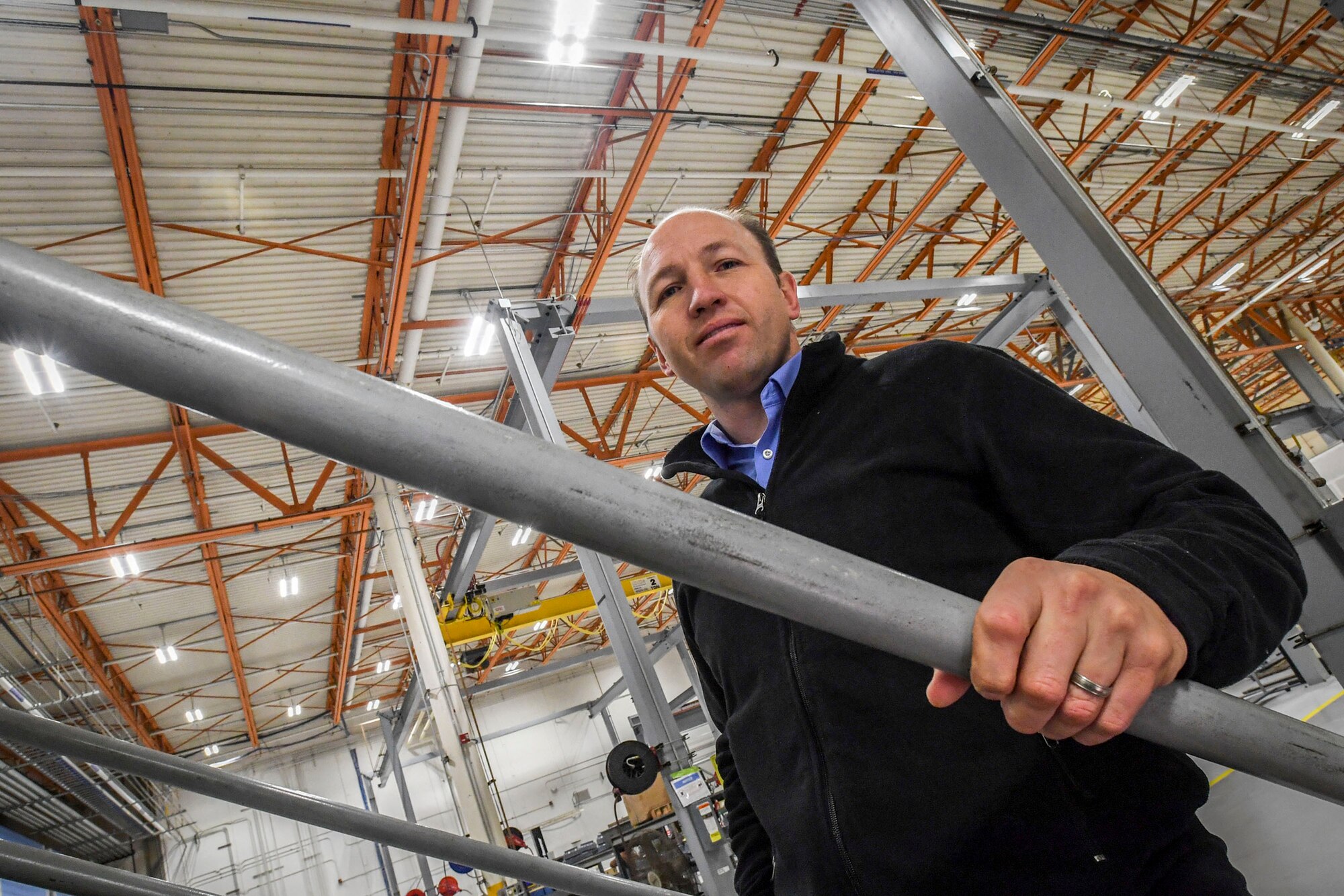 Aaron Erickson, 309th Maintenance Support Group energy manager, stands beneath a field of LED lights at building 843, Hill Air Force Base, Dec. 13. The LED lights recently replaced halide bulbs, resulting in significant electricity savings. Erickson was recently named as the 2016 Energy Champion of the Year for the base. (U.S. Air Force photo by Paul Holcomb)