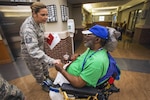 Master Sgt. Jamie Ludy, 177th Maintenance Squadron, gives Air Force Vietnam veteran Ed Taylor a card during the 16th Annual Holiday "Songfest" at the New Jersey Veterans Memorial Home at Vineland, N.J., Dec. 13, 2016. More than 80 fourth graders from the Seaview Elementary School in Linwood, N.J., and 18 Airmen sang holiday songs and handed out cards to the Home’s residents during the event. 