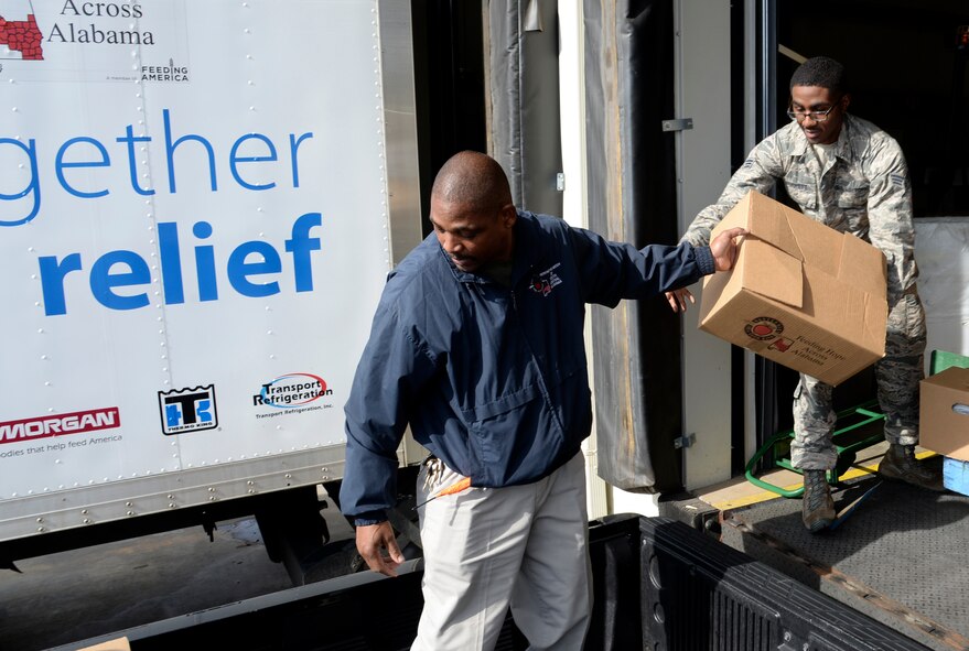 Senior Airman Joshua Duckett, Holm Center non-commissioned officer in charge of protocol, helps unload boxes of donated food items for the Montgomery Food Bank, Dec. 15, 2016, Montgomery, Ala. Duckett along with several other Airmen volunteered the night before during the annual Airmen of Note Glenn Miller concert and food drive. Before entrance into the show attendees donated all together 463 pounds of non-perishable food. (US. Air Force photo/ Senior Airman Alexa Culbert)