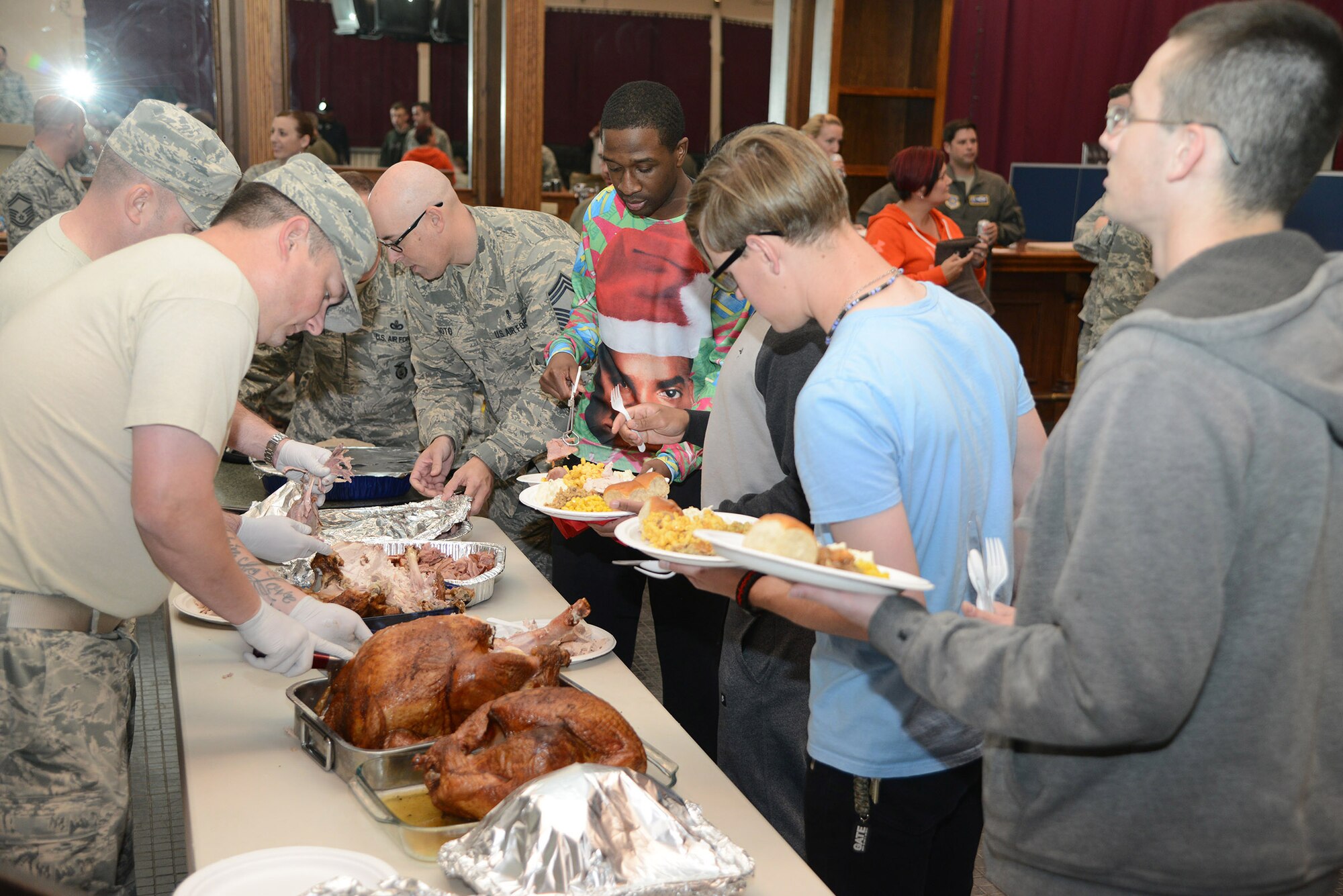 Airmen line up for some holiday dining and fellowship in the Stripes Lounge at the Oasis Community Center to take part in a holiday meal Tuesday. The holiday meal was organized and presented to the dormitory residents by Edwards Top Three and the First Sergeants Council. (U.S. Air Force photo by Christopher Ball)