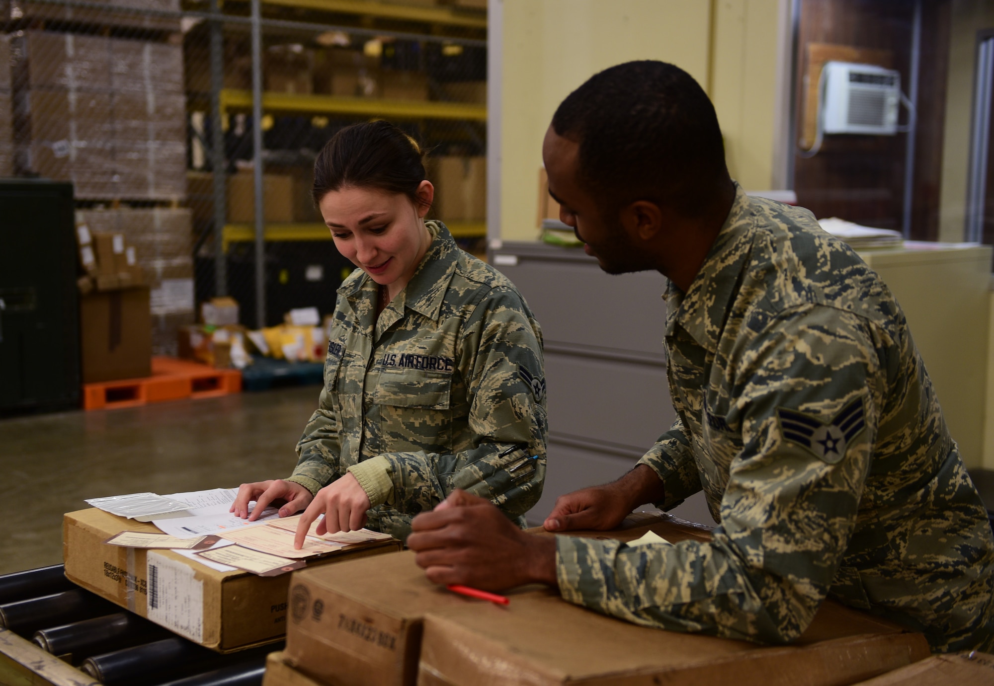 Airman 1st Class Alyssa Dreksler receives mentoring on packaging receipts from Senior Airman Jordan Fishburne, Flight Service Center technicians assigned to the a 28th Logistics Readiness Squadron, at Ellsworth Air Force Base, S.D., Dec. 6, 2016. Flight Service Center Airmen ensure all parts received are logged correctly to prevent any delays in repairs. (U.S. Air Force photo by Airman 1st Class James L. Miller)