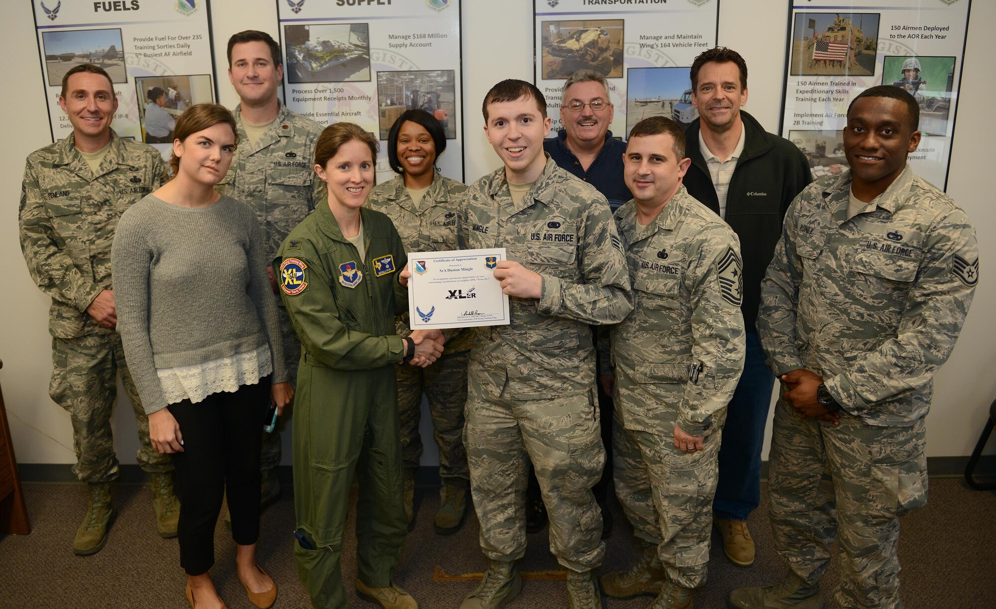 Senior Airman Duston Mingle, 47th Logistics Readiness Flight Squadron logistics planner (front center), accepts the “XLer of the Week” award from Col. Michelle Pryor (front left), 47th Flying Training Wing vice commander, and Chief Master Sgt. George Richey, 47th FTW command chief (front right), on Laughlin Air Force Base, Texas, Dec. 7, 2016. The XLer is a weekly award chosen by wing leadership and is presented to those who consistently make outstanding contributions to their unit and Laughlin. (U.S. Air Force photo/Airman 1st Class Benjamin N. Valmoja)