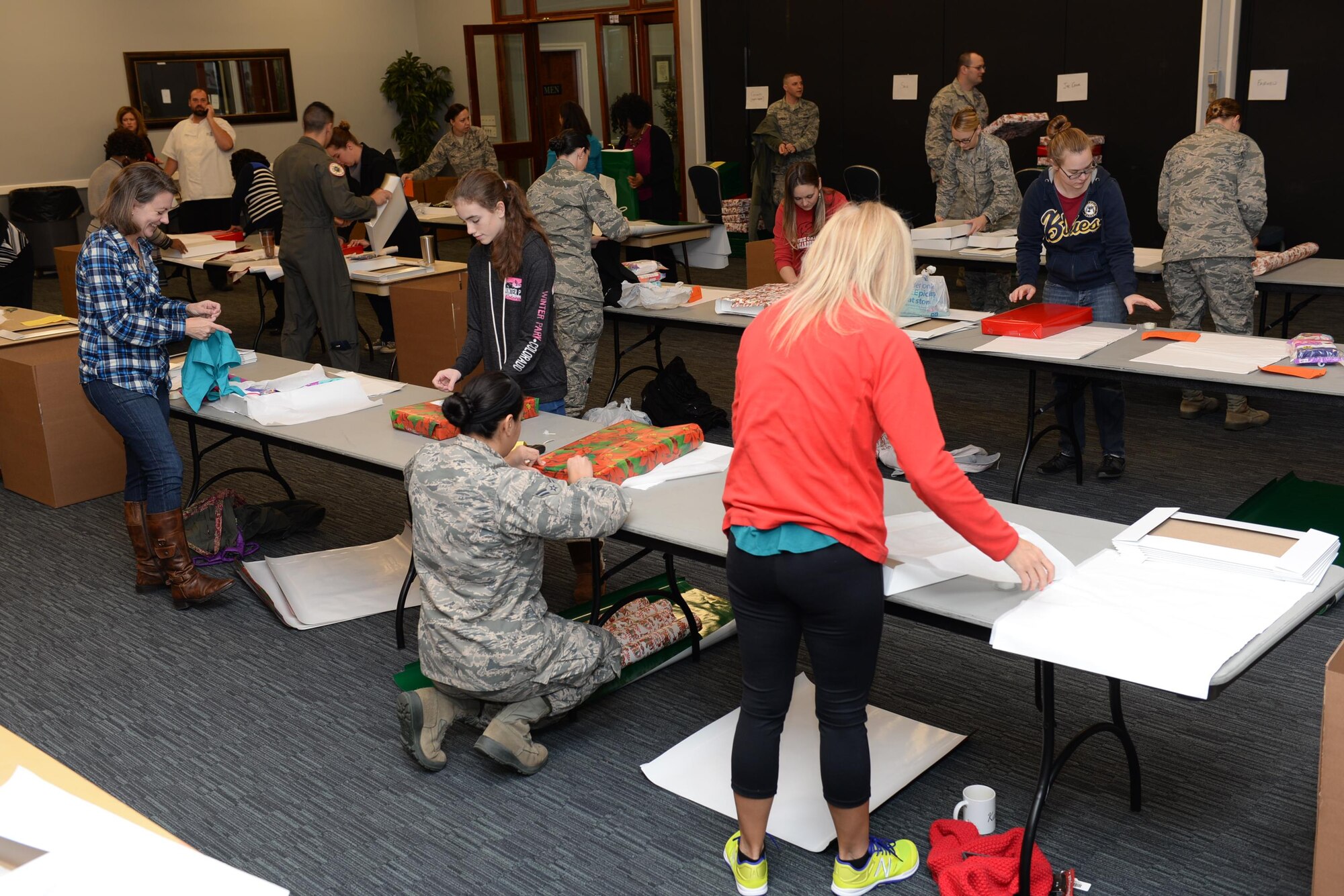 Team BLAZE members volunteer to wrap presents at the Happy Irby Fund Shop and Wrap Dec. 8, 2016, at Columbus Air Force Base, Mississippi. The Happy Irby Shop and Wrap provides underprivileged children with wrapped presents containing clothing, school supplies, outfits and other basic necessities. (U.S. Air Force photo by Senior Airman John Day)