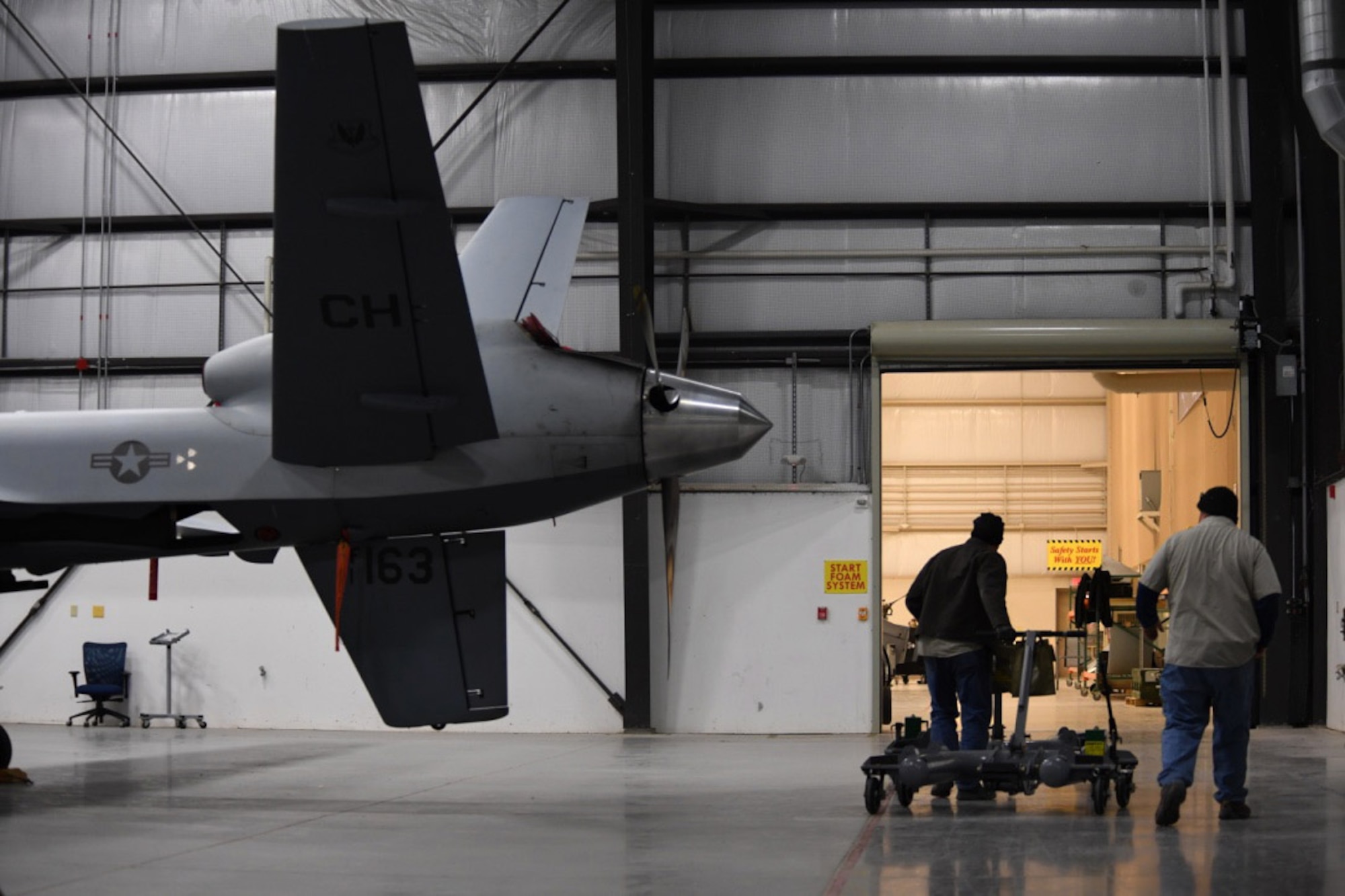 Robert and Michael, aerospace ground equipment mechanics with the 432nd Wing/432nd Air Expeditionary Wing, move equipment toward the exit of a hangar Dec. 6, 2016, at Creech Air Force Base, Nev. Robert and Michael maintain about 100 pieces of AGE that are essential to MQ-1 Predator MQ-9 Reaper operations. (U.S. Air Force photo by Airman 1st Class James Thompson) 