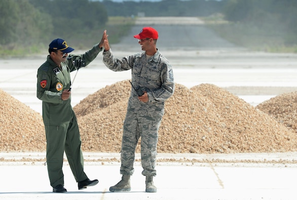 Indian Air Force Wing Commander Janardhana Reddy Neelam high-fives U.S. Air Force Master Sgt. Simon Zika, 554th RED HORSE Squadron, during a subject-matter expert exchange Oct. 25, 2016, at Northwest Field, Guam. The subject-matter expert exchange focused on airfield damage repair using folded fiberglass matting. These exchanges provide an opportunity for the U.S. Air Force and its international partners to enhance each other’s capabilities, improve interoperability and fundamentally provide highly skilled coalition engineers for operations in a variety of environments. (U.S. Air Force photo by SSgt. Benjamin Gonsier/Released)

