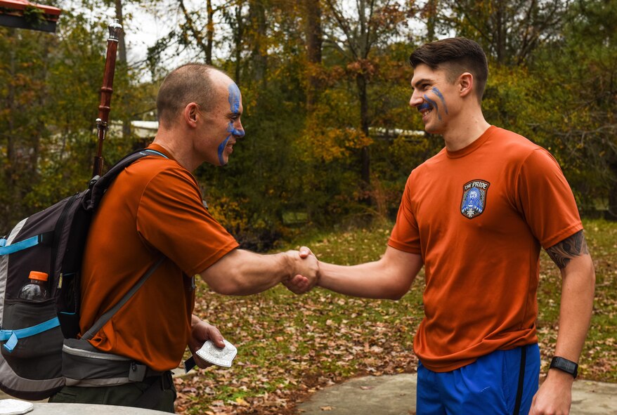 U.S. Air Force Staff Sgt. Garrett Allen, 608th Air Operations Center strategy division planner, shakes hands with Col. Glen Shilland, 608th AOC commander, after completing a 6.08-mile ruck march as part of a PT program capstone event at Barksdale Air Force Base, La., Dec. 12, 2016. The 608th AOC Commander’s Advanced PT requires participants to complete 3,000 push-ups, 3,000 sit-ups, run 120 miles and complete a 6.08 mile ruck march within a 90-day period to earn their name on an ingot attached to the fitness plaque. The program is intended to encourage habitual fitness, boost morale and serve as an initiative to seeking out new fitness regimes. (U.S. Air Force photo by Senior Airman Luke Hill)