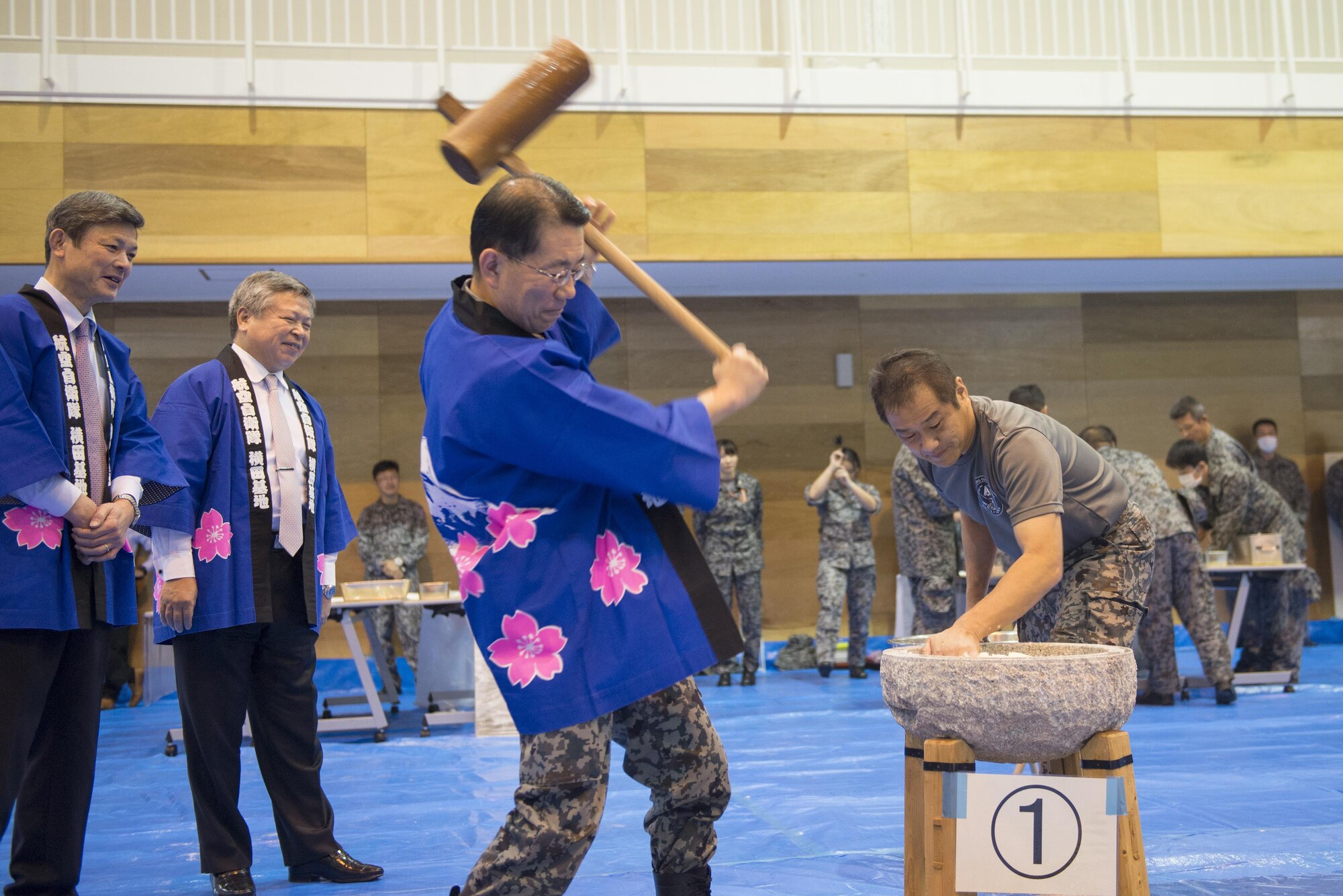 Japan Air Self-Defense Force Col. Shuichi Kamada, Operation Support Wing commander, demonstrates the correct way to pound mochi during a traditional Japanese event at Yokota Air Base, Japan, Dec. 14, 2016. Mochitsuki, or rice pounding, is a ceremony held in preparation for New Year celebration. (U.S. Air Force photo by Senior Airman David C. Danford/Released)