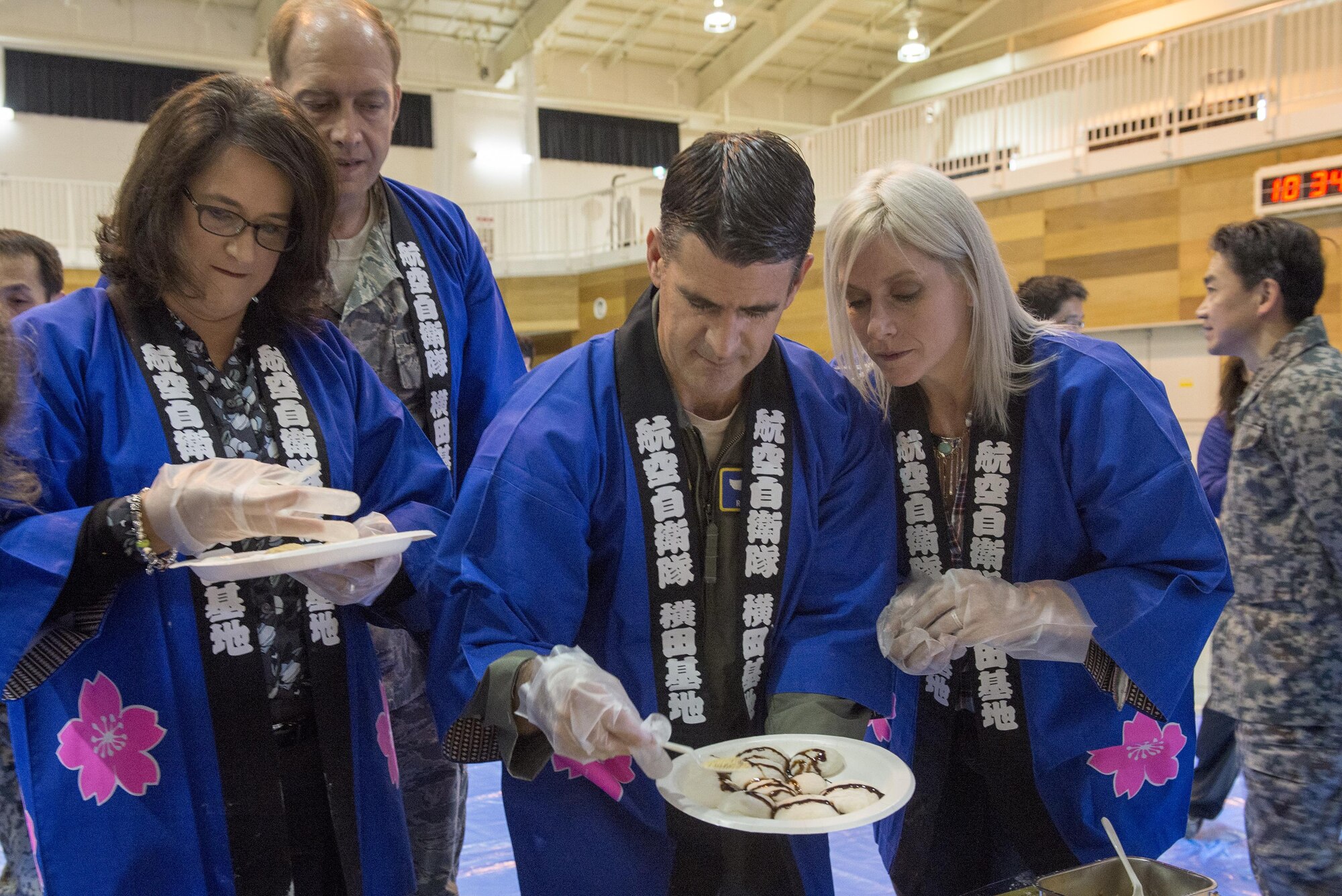 Col. Robert Dotson, 374th Operations Group commander, gathers mochi for tasting at a traditional Japanese event hosted by the Japan Air Self-Defense Force at Yokota Air Base, Japan, Dec. 14, 2016. Sweets, sugars or toasted soy bean powder are often added to mochi before eating. (U.S. Air Force photo by Senior Airman David C. Danford/Released)