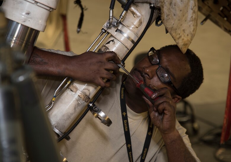 U.S. Air Force Staff Sgt. Byron Cole, a 14th Aircraft Maintenance Unit crew chief, removes a flathead screwdriver wire harness clamps from an F-16 Fighting Falcon tension strut at Misawa Air Base, Japan, Dec. 12, 2016. The wire harness controls the speed transducer which ensures the aircraft wheels are turning at the same speed to prevent abrupt turns. (U.S. Air Force photo by Airman 1st Class Sadie Colbert)