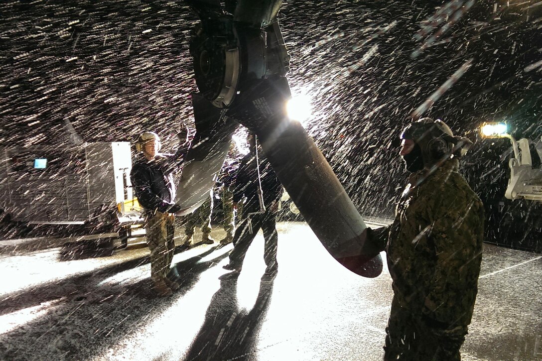 As snow streams down, sailors change a prop on an EP-3E Aries II aircraft during a night check at Naval Air Station Whidbey Island in Oak Harbor, Wash., Dec. 11, 2016. The sailors are assigned to Fleet Air Reconnaissance Squadron 1. The aircraft provides fleet and theater commanders worldwide with real-time tactical signals intelligence and motion video intelligence. Navy photo