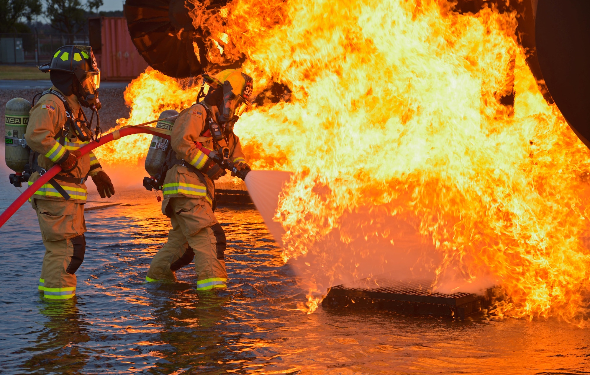 Two firefighters with the 374th Civil Engineer Squadron put out a simulated aircraft fire during a training scenario at Yokota Air Base, Japan, Dec. 14, 2016. The training consisted of a training aircraft burning with two engine fires with leaking fuel spreading on the ground to simulate an aircraft on the runway needing assistance. (U.S. Air Force photo by Staff Sgt. David Owsianka)