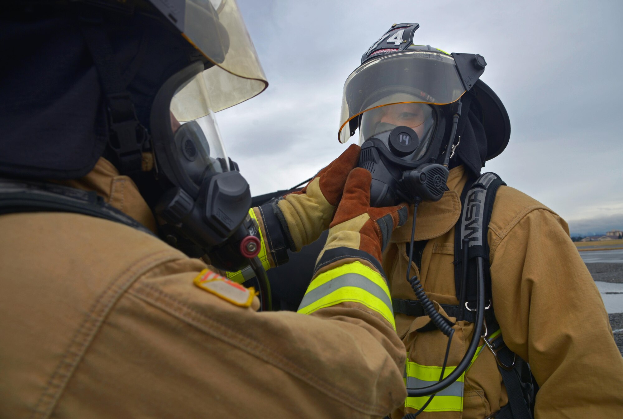 Two firefighters with the 374th Civil Engineer Squadron perform an equipment check prior to completing a training scenario at Yokota Air Base, Japan, Dec. 14, 2016. The training helped the firefighters gain experience and build cohesiveness to work as a better team for potential real-world scenarios. (U.S. Air Force photo by Staff Sgt. David Owsianka)