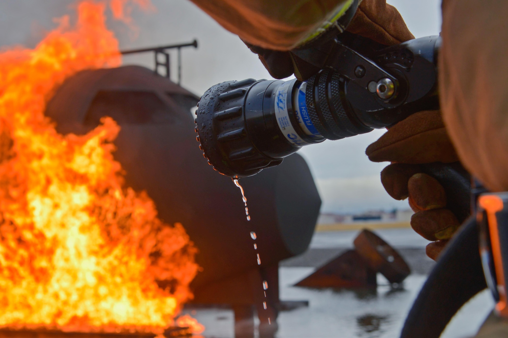 A firefighter with the 374th Civil Engineer Squadron holds a fire hose during a training scenario at Yokota Air Base, Japan, Dec. 14, 2016. The training helped the firefighters gain experience and build cohesiveness to work as a better team for potential real-world scenarios. (U.S. Air Force photo by Staff Sgt. David Owsianka)