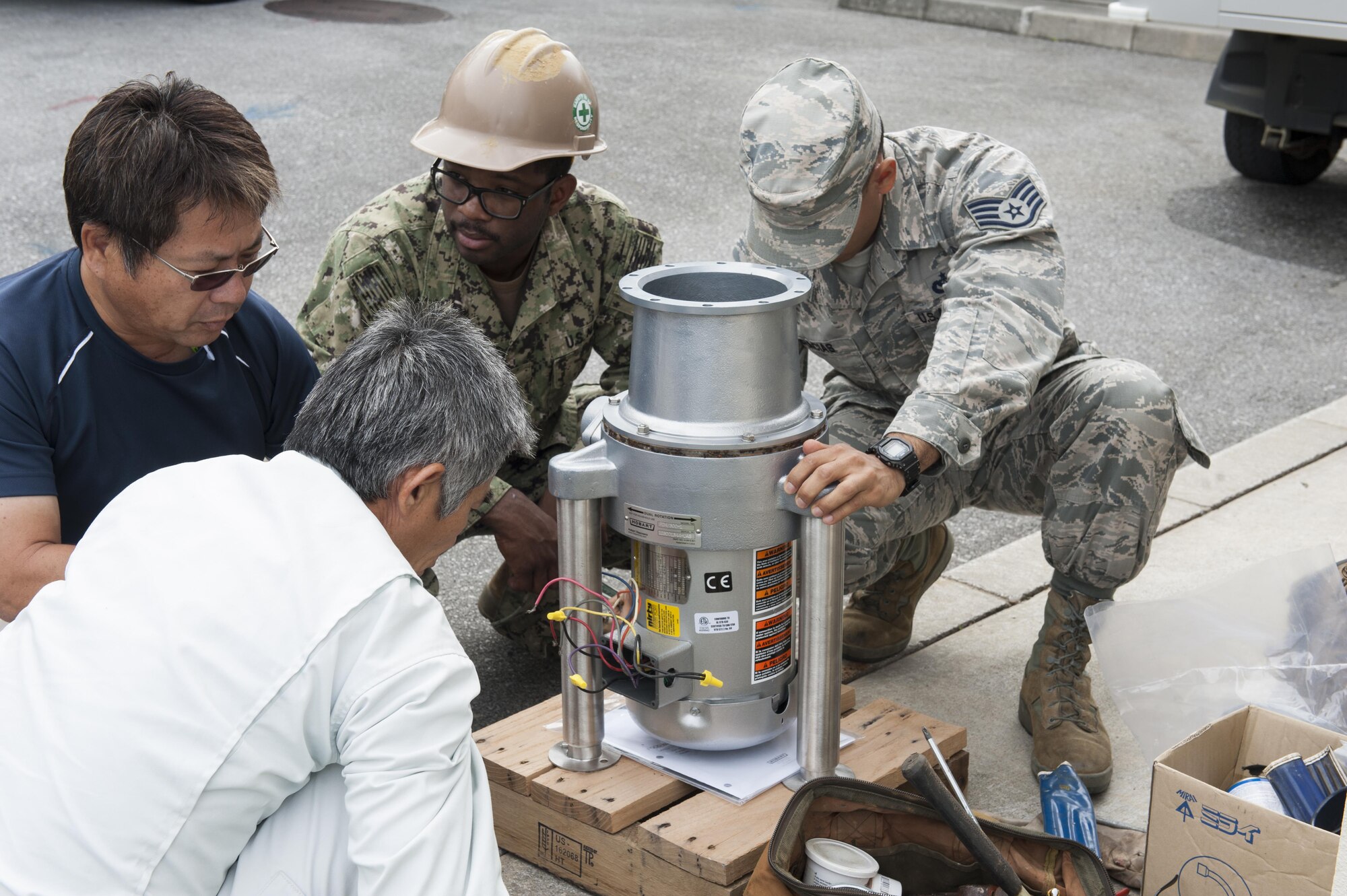 Members of the 18th Civil Engineer Squadron Water and Fuels Systems Maintenance team prepare a garbage disposal for installment at the Tee House Dec. 7, 2016, at Kadena Air Base, Japan. WFSM is responsible for installing equipment related to water and fuels to different areas of the base. (U.S. Air Force photo by Senior Airman Lynette M. Rolen/Released)