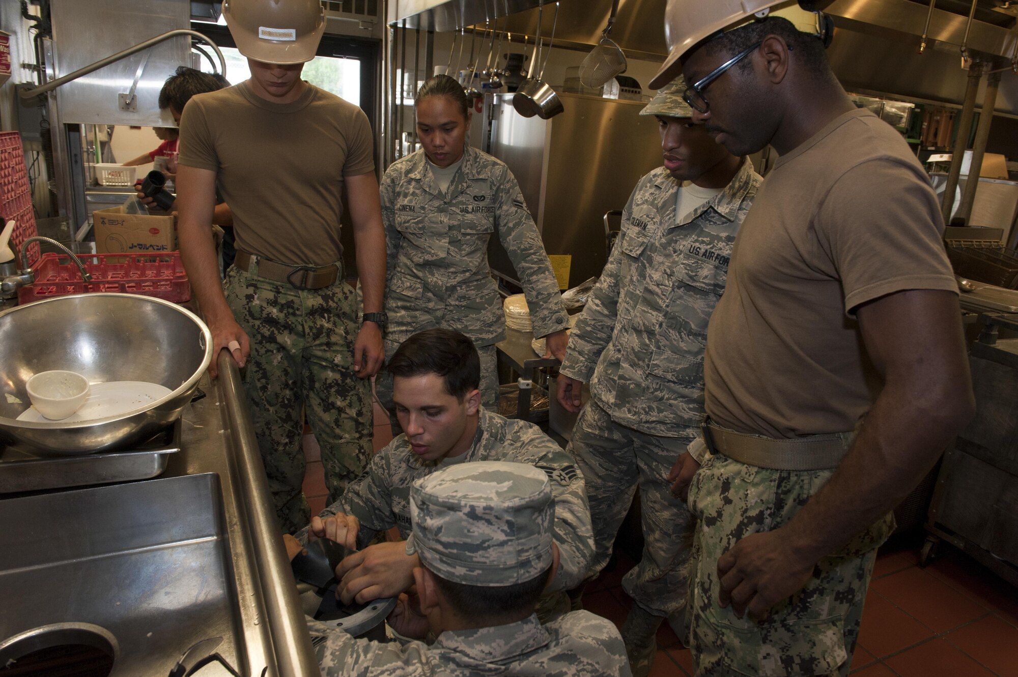 Members of the 18th Civil Engineer Squadron Water and Fuels Systems Maintenance team install a new garbage disposal unit in the Tee House Dec. 7, 2016, at Kadena Air Base, Japan. The Tee House is a historical building on Kadena and first opened in January of 1967. (U.S. Air Force photo by Senior Airman Lynette M. Rolen/Released)