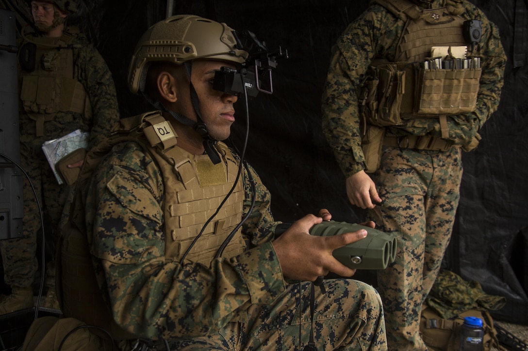 Lance Cpl. Jorge Brito uses the Augmented Immersive Team Trainer to call in mortar fire on virtual targets at Camp Lejeune, N.C., Dec. 13, 2016. Brito is holding a Target Hand-Off System integrated with the AITT to spot out virtual tanks while getting coordinates to call in mortar fire. Brito is a fire support Marine with 2nd Battalion, 10th Marine Regiment, 2nd Marine Division. (U.S Marine Corps photo by Lance Cpl. Juan A. Soto-Delgado)