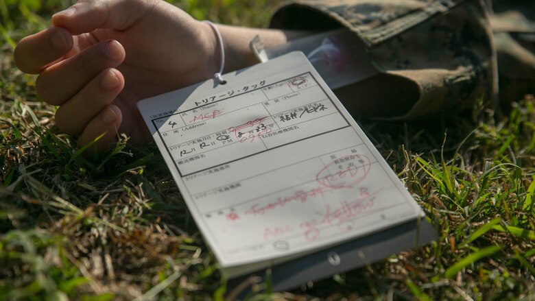 A medical card lays tied around a role player’s wrist Dec. 12 during Exercise Constant Vigilance 2016 at Camp Hansen, Okinawa, Japan. Constant Vigilance is an annual exercise that sharpens MCIPAC emergency response skills on bases across Okinawa through rehearsals and drills in varying scenarios. During the casualty evacuation, Marines with Camp Hansen Marines cleared a mock collapsed building and removed simulated casualties. Upon removing the personnel inside the building, the Marines assessed casualties’ medical needs and escorted them to the landing zone to transport them out of the area to receive advanced medical care.