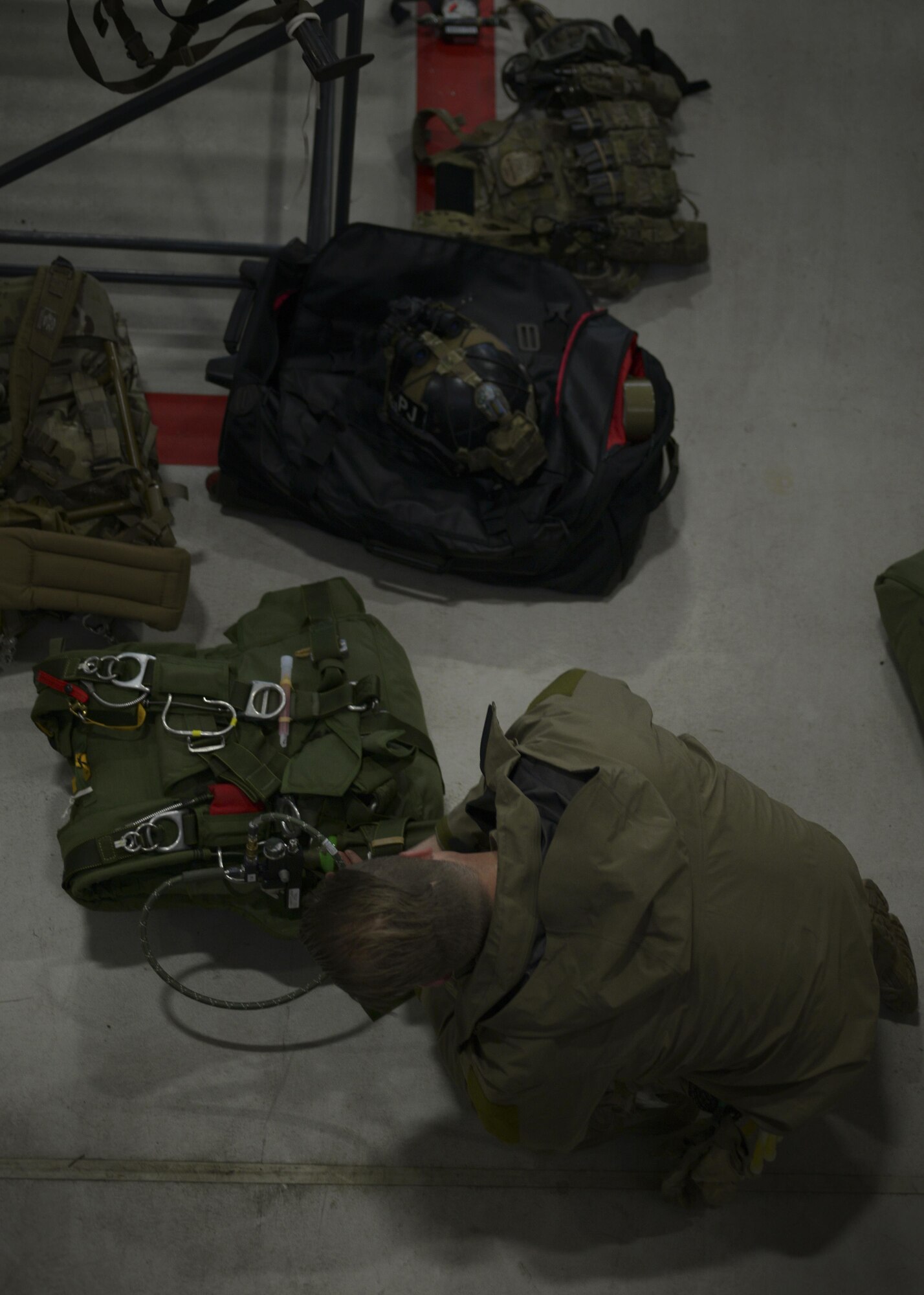 An Air Commando from the 321st Special Tactics Squadron affixes an oxygen tank to a parachute pack in preparation for a high altitude, low opening parachute jump Dec. 14, 2016, on RAF Mildenhall, England. A HALO jump is a Military Free Fall and, without oxygen, can render the jumper unconscious. (U.S. Air Force photo by Staff Sgt. Victoria H. Taylor)