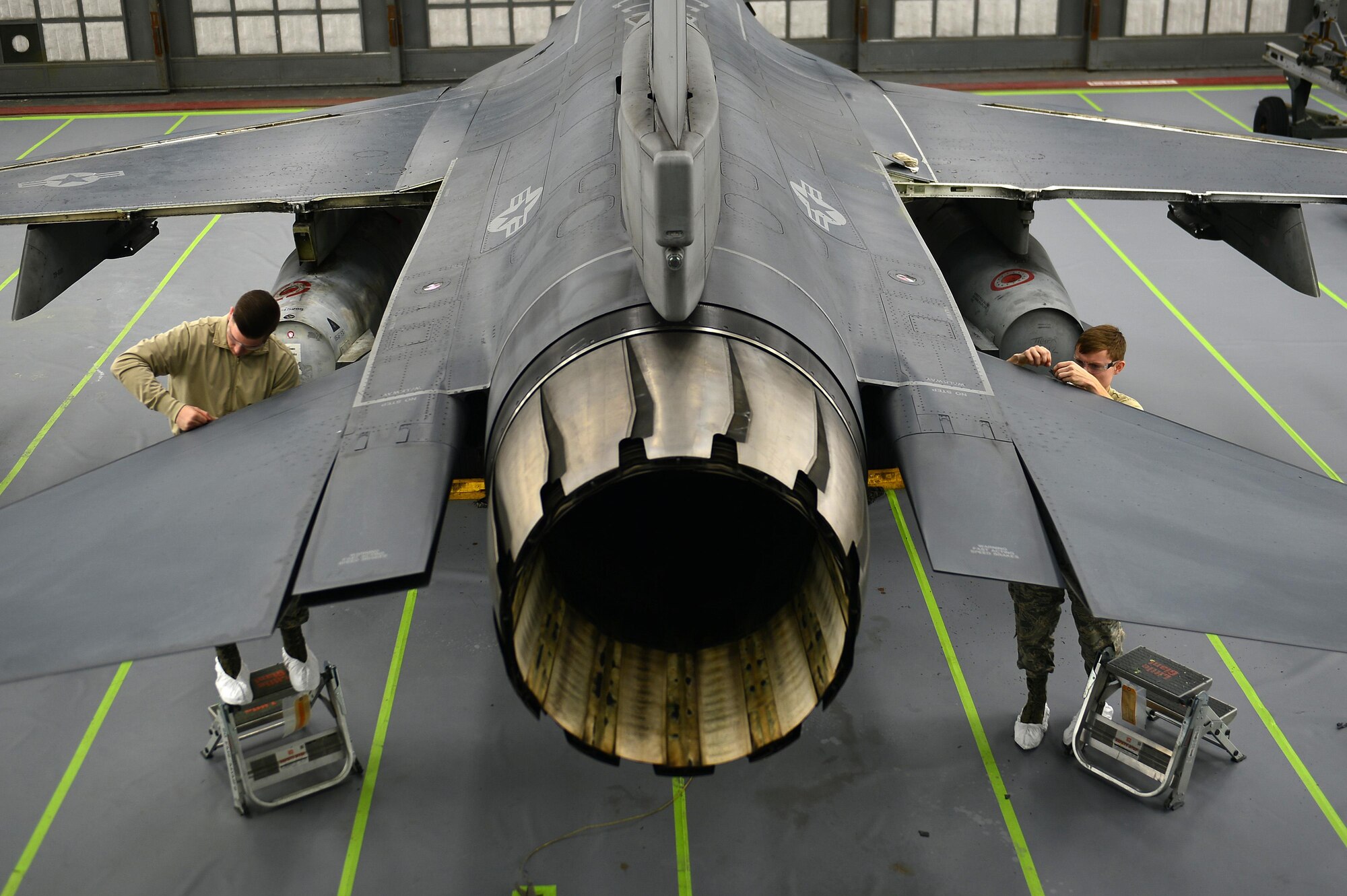 Airman 1st Class Zachary Bradley (left) and Airman Joseph Glenn, 20th Equipment Maintenance Squadron aircraft structural maintenance apprentices, remove leading edge tape prior to painting an F-16CM Fighting Falcon at Shaw Air Force Base, S.C., Dec. 14, 2016. Leading edge tape serves as a repellent against rain and prevents the F-16’s wing edges and tail flaps from rusting and corroding. (U.S. Air Force photo/Airman 1st Class Christopher Maldonado)