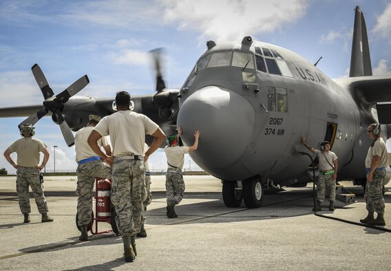 C-130H Hercules maintainers, assigned to the 374th Maintenance Group, prepare an aircraft for takeoff during Operation Christmas Drop 2016 at Andersen Air Force Base, Guam, Dec. 7, 2016. The maintainers of OCD adapted to a high operational tempo and made sure aircraft were safe and ready to fly daily. (U.S. Air Force photo/Senior Airman Elizabeth Baker)