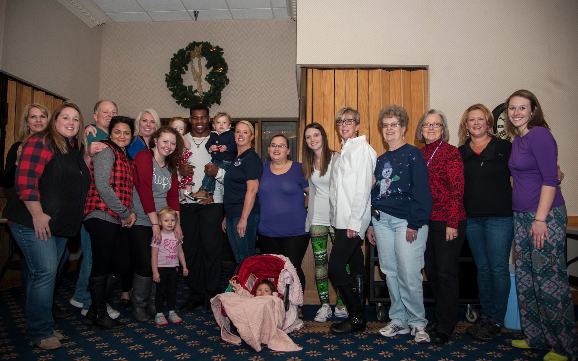 Former Heisman Trophy winner Herschel Walker takes a moment to pose with members of the Kirtland Spouses' Club during his visit to Kirtland Dec. 12-13.  Walker spoke at multiple venues on base, detailing his struggles with mental illness and encouraging those with issues to seek help.  