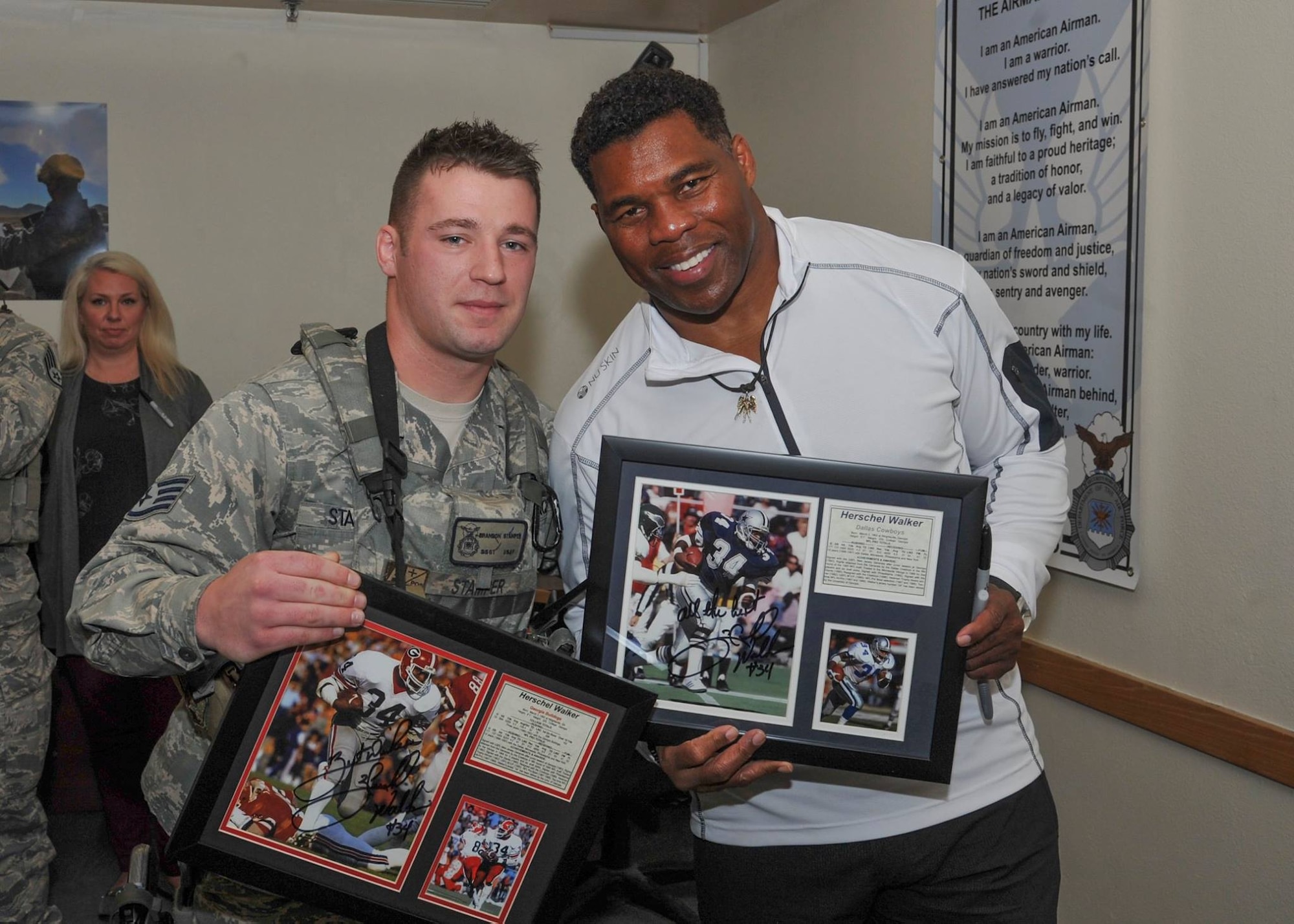 Former pro football player Herschel Walker poses with plaques he signed for Staff Sgt. Brandon Stamper of the 377th Weapons System Security Squadron during his visit to the base Dec. 12-13. Walker came to the base to tell Airmen about his suffering with a mental illness. He said there is no shame in asking for help.