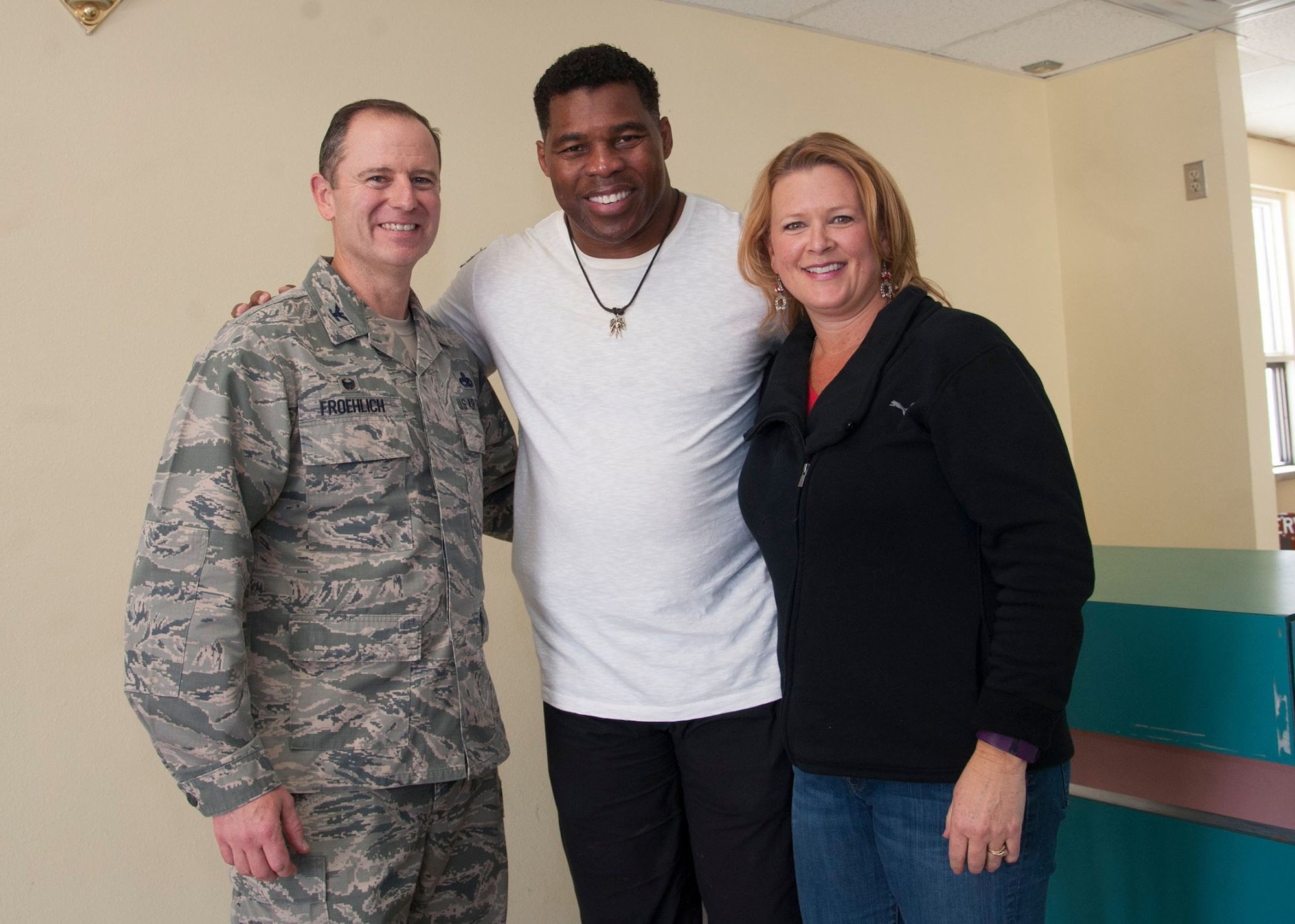 Former Heisman Trophy winner Herschel Walker takes a moment to pose with Col. Eric Froehlich, 377th Air Base Wing commander, and his wife Stephanie, during his visit to Kirtland Dec. 12-13.  Walker spoke at multiple venues on base, detailing his struggles with mental illness and encouraging those with issues to seek help.  