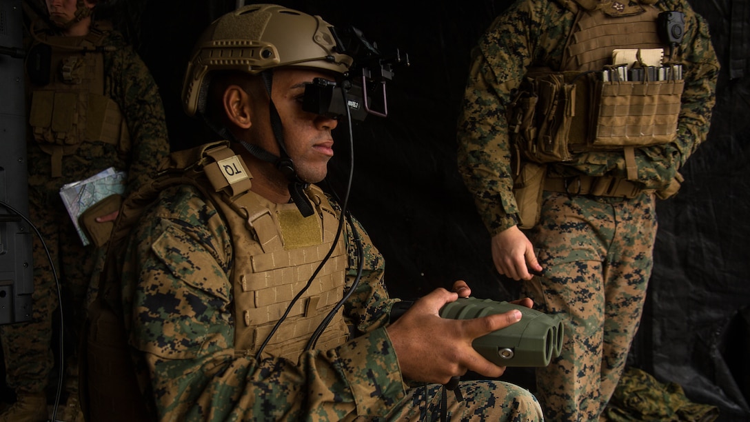 Lance Cpl. Jorge Brito uses the Augmented Immersive Team Trainer to call in mortar fire on virtual targets at Marine Corps Base Camp Lejeune, N.C., Dec. 13, 2016. Brito is holding a Target Hand-Off System integrated with the AITT to spot out virtual tanks while getting coordinates to call in mortar fire. Brito is a fire support Marine with 2nd Battalion, 10th Marine Regiment, 2nd Marine Division. 